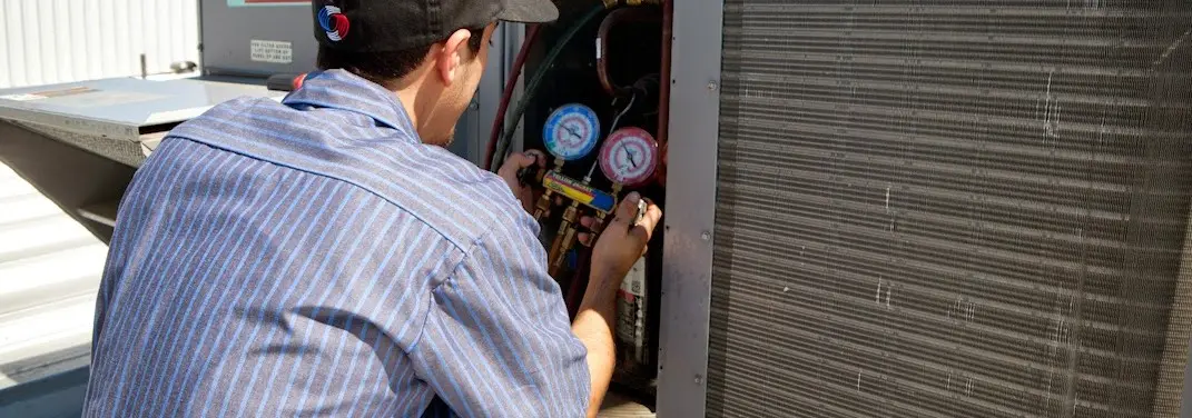 HVAC technician servicing a condenser unit in East Brandywine