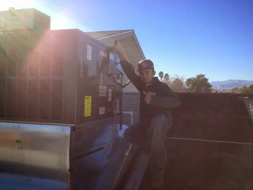 HVAC technician performing Heat Pump Repair on a rooftop unit in East Brandywine